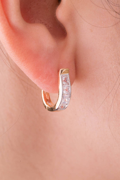 Oorbellen. Gouden hoepel oorbellen met diamanten op de witte achtergrond. - Foto, afbeelding