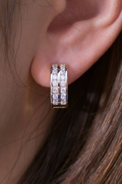 Boucles d'oreilles. Boucles d'oreilles cerceau d'or avec diamants sur le fond blanc
. - Photo, image