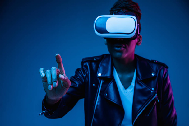Young african-american womans using VR-glasses in neon light - Photo, image