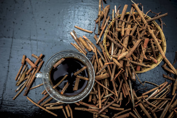 Joukko Intian madderwort tai madder root ruskea-värinen kori musta puupinta tunnetaan myös nimellä manjistha / manzistha / Rubia cordifolia / madder jne sen teetä lasi kuppi
. - Valokuva, kuva