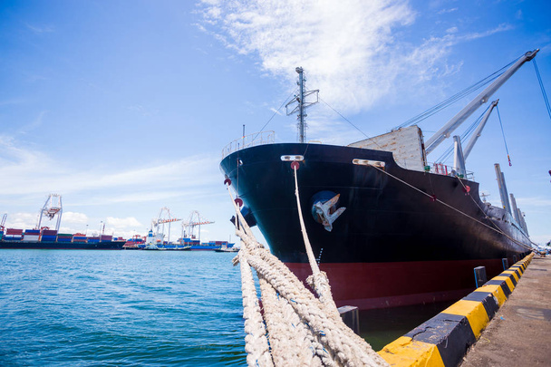 Грузовое судно загружается краном в порту Лемчабанг, Таиланд. Логистика и транспортировка грузового судна с рабочим крановым мостом на фоне голубого неба. Логистический экспорт и транспортные индуисты
 - Фото, изображение
