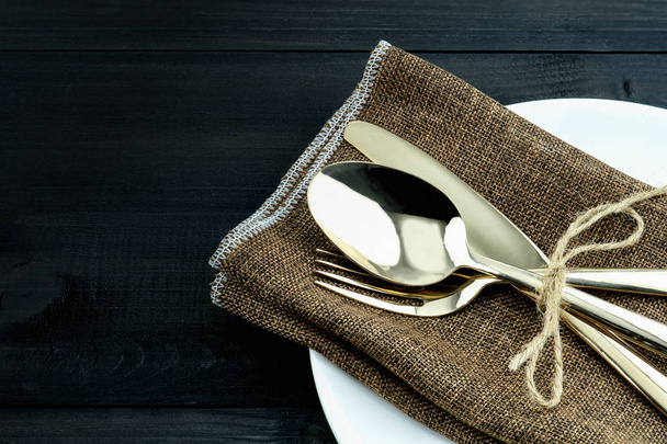 A set of bronze cutlery, spoon, fork and knife arrange on napkin - Photo, Image