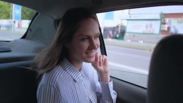  Brunette girl rides in taxi in backseat enjoying the ride. - Filmati, video