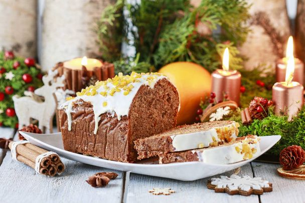 Рождественский пряничный торт среди традиционных украшений
.  - Фото, изображение