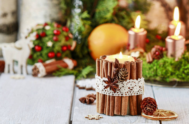 Candle decorated with cinnamon sticks. Christmas arrangement. - 写真・画像