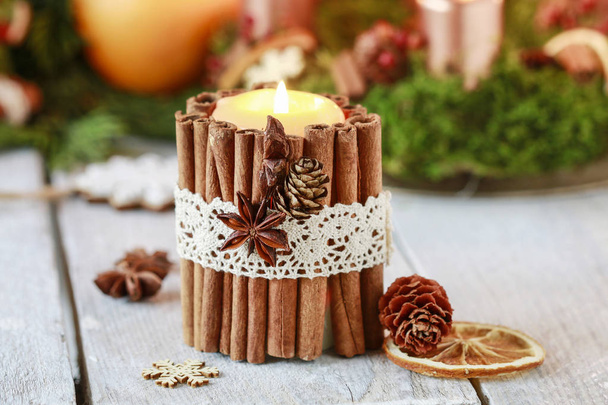 Candle decorated with cinnamon sticks - Φωτογραφία, εικόνα