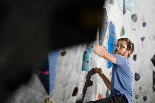healthy active young sport bearded man in glasses climbing on wa - Photo, Image