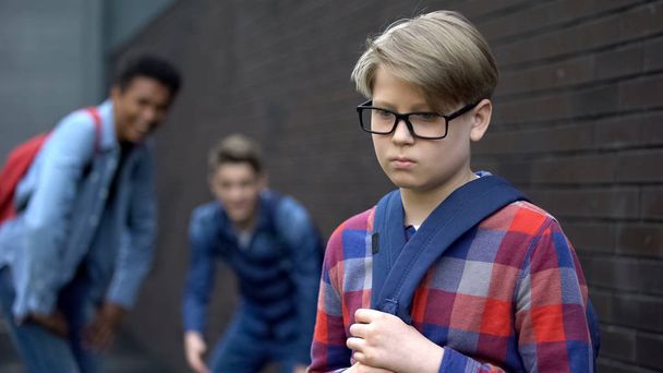 Evil teen boys laughing at new student in school, calling names, verbal bullying - Fotoğraf, Görsel