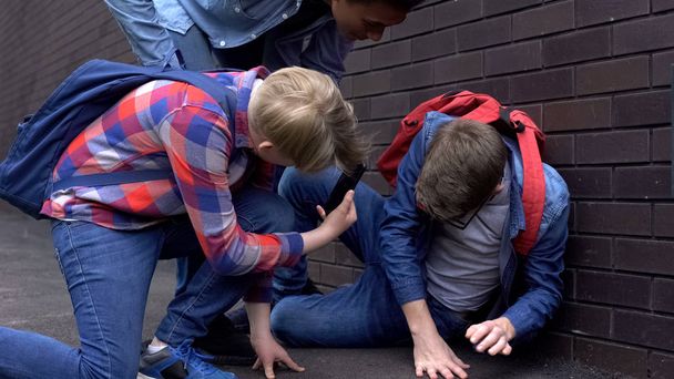 Aggressive teens making compromising video on phone, bullying intimidating boy - Фото, изображение