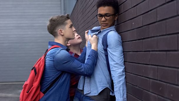 Students bullying afro-american boy outdoors, racism in schools, teenage cruelty - Фото, зображення