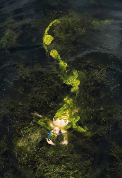 mooie sexy zeemeermin met blauw haar en lange vis staart van algen Drifts in het water - Foto, afbeelding