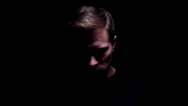 Shadowed man looking down, maniac preparing for cruel murder, criminal - Valokuva, kuva