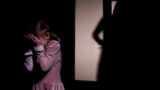 Little girl afraid of dark male silhouette opening room door, horror nightmare - 写真・画像