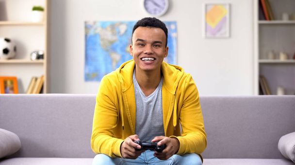 Game addicted Afro-American teenage boy winning computer game, procrastination - Foto, afbeelding