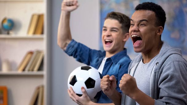 Emotional multiracial teenage friends cheering for national soccer team, fans - Foto, Imagen