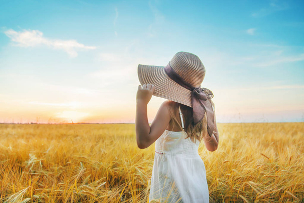 A child in a wheat field. Sunset. Selective focus. - 写真・画像