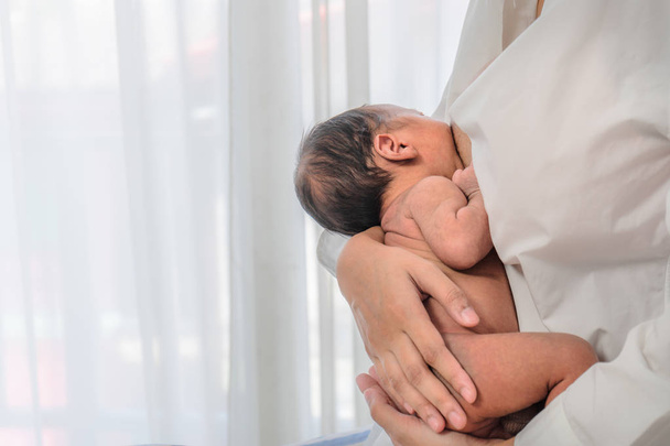 mother in white shirt having breast  feeding to her baby boy - Foto, Bild