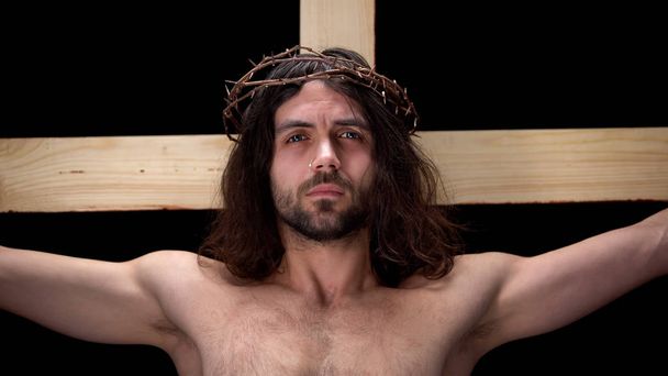 Crying Messiah in crown thorns, sacrificing life, suffering crucifix, religion - 写真・画像