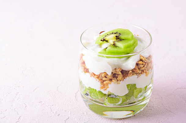 close up of dessert with kiwi, granola and cottage cheese on pink background - 写真・画像