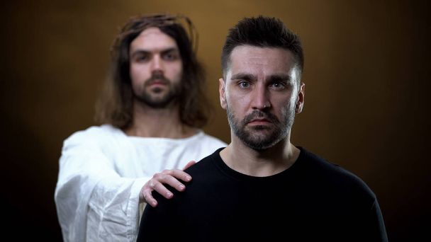 Jesus Christ supporting desperate man, preventing crime, religious peace, help - 写真・画像