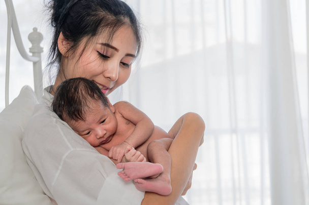Asian mother holding her baby boy on hand with happiness - Fotografie, Obrázek