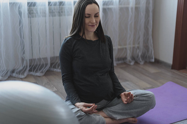 Medytacja Kobieta w ciąży z skrzyżowanymi nogami - Zdjęcie, obraz