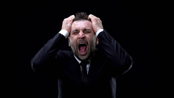 Worried businessman shouting on dark background, mental exhaustion, pressure - Fotó, kép