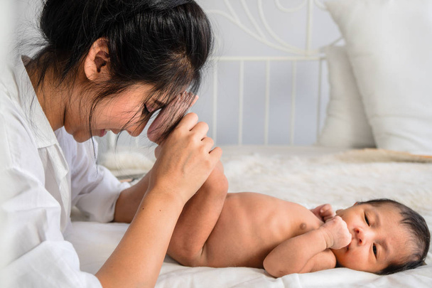 Asian mother holding her infant baby boy feet on hand - Fotografie, Obrázek