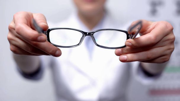 Doctor suggesting eyeglasses for person with refocused vision, sight improvement - 写真・画像