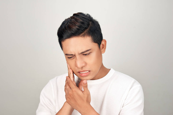 Retrato de homens asiáticos com os olhos preocupação usar a mão tocando sua bochecha, sente dor de dor de dente. Conceito de doença dentária e bucal
. - Foto, Imagem