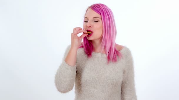 Una giovane donna si sta godendo il gusto di un biscotto
. - Filmati, video