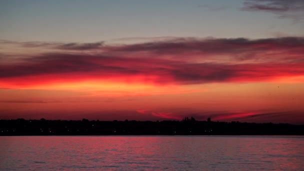 Punainen-oranssi auringonnousu meren rannalla
 - Materiaali, video