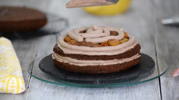 Nahaufnahme: Kekscreme in Form einer Spirale auf dem Kuchen. Schokoladenbiskuit mit Sahne. Zubereitung von Kuchen in einem Süßwarenladen. das Essen für den Urlaub. - Filmmaterial, Video