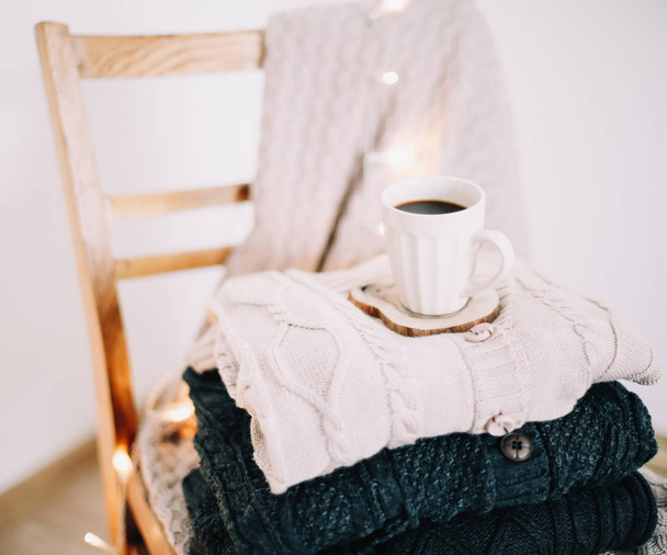 Top view of cup of coffee with a knitted beige plaid on background. Autumn and winter, leisure concept. Flat lay - Foto, immagini