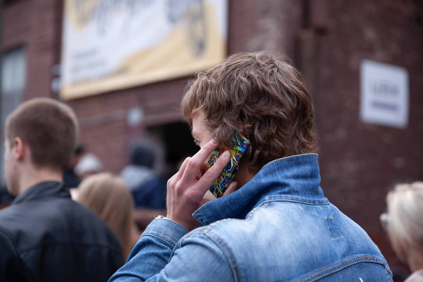 Belarus, Minsk, may 17, 2015, Oktyabrskaya street, biker festival. man talking on a mobile phone on a city street - Fotó, kép