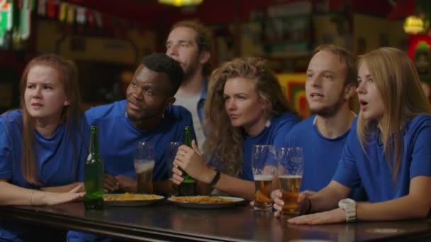 sport, mensen, vrije tijd, vriendschap en entertainment concept - gelukkig voetbalfans of mannelijke vrienden drinken bier en vieren overwinning bij bar of pub. - Video