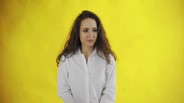 Portret van ernstige jonge vrouw schuddende hoofd en het uiten van ontkenning, geïsoleerd over gele achtergrond - Video