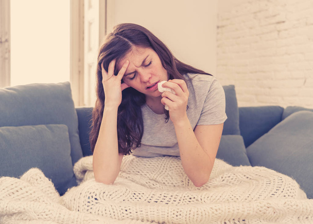 Sick woman on sofa sneezing and blowing her nose with allergy, hay fever or cold feeling unwell, fatigue and restless not being able to go to work. Lifestyle portrait In Health Care and medical. - Photo, Image