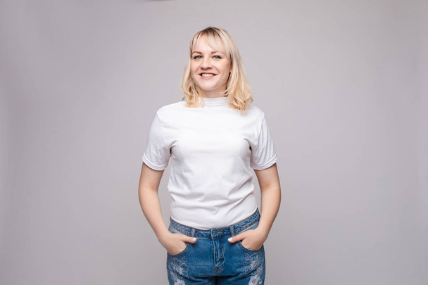 schlanke Frau mit weißem Hemd und Jeans im Stehen - Foto, Bild