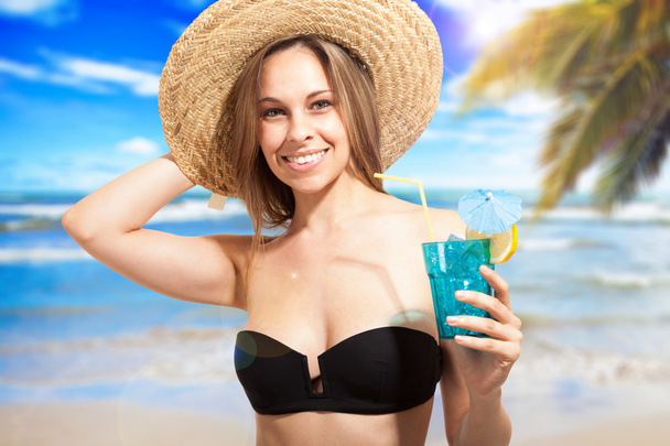 Woman drinking a cocktail on the beach - Fotó, kép