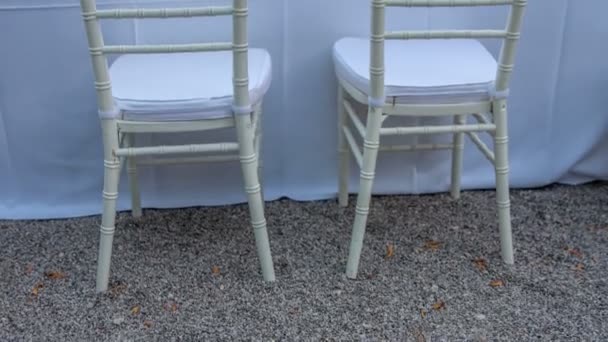 Dwa odnowione białe krzesła położone na piasku - Materiał filmowy, wideo
