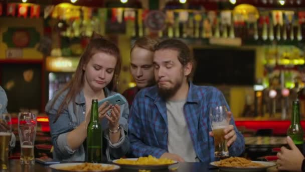 Οι άνθρωποι, άνδρες, αναψυχής, φιλία και τεχνολογία έννοια - happy αρσενικό φίλοι, πίνοντας μπύρα και λαμβάνοντας αυτοπορτρέτα με smartphone στο μπαρ ή παμπ. - Πλάνα, βίντεο