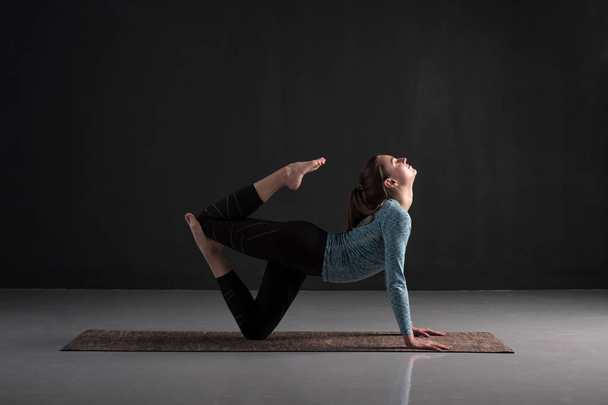 junge Frau, die Yoga praktiziert, trainiert. Innenraum in voller Länge - Foto, Bild