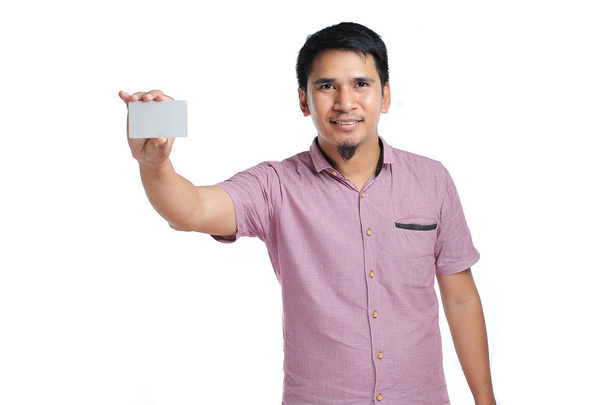 Portrait d'homme asiatique souriant tenant une carte de visite vierge blanche
 - Photo, image
