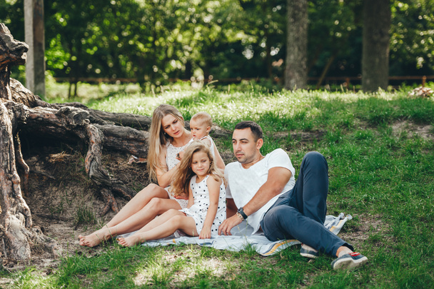 Familia con niños disfrutando de un picnic en el bosque de verano
. - Foto, Imagen