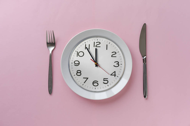 プレート上の時計とピンクのテーブルの設定 - 写真・画像