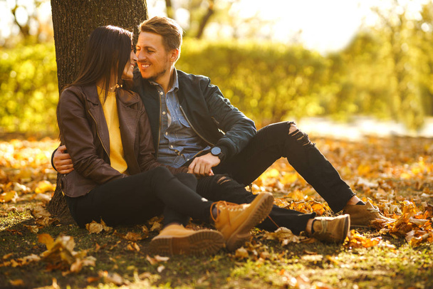 Lovely beautiful couple enjoying each other.  Beautiful autumn day. Lifestyle, happy couple of two play on a sunny day in the park. The concept of youth, love and lifestyle. - Foto, Imagem