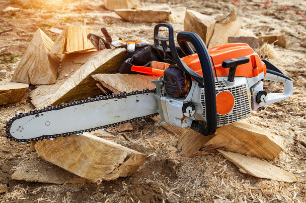 Chainsaw for a tree. Sawing firewood outdoors. - Fotó, kép