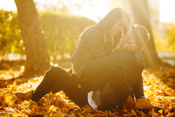 Lovely beautiful couple enjoying each other.  Beautiful autumn day. Lifestyle, happy couple of two play on a sunny day in the park. The concept of youth, love and lifestyle. - Foto, imagen