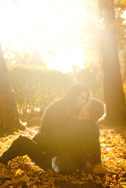 Lovely beautiful couple enjoying each other.  Beautiful autumn day. Lifestyle, happy couple of two play on a sunny day in the park. The concept of youth, love and lifestyle. - Foto, imagen